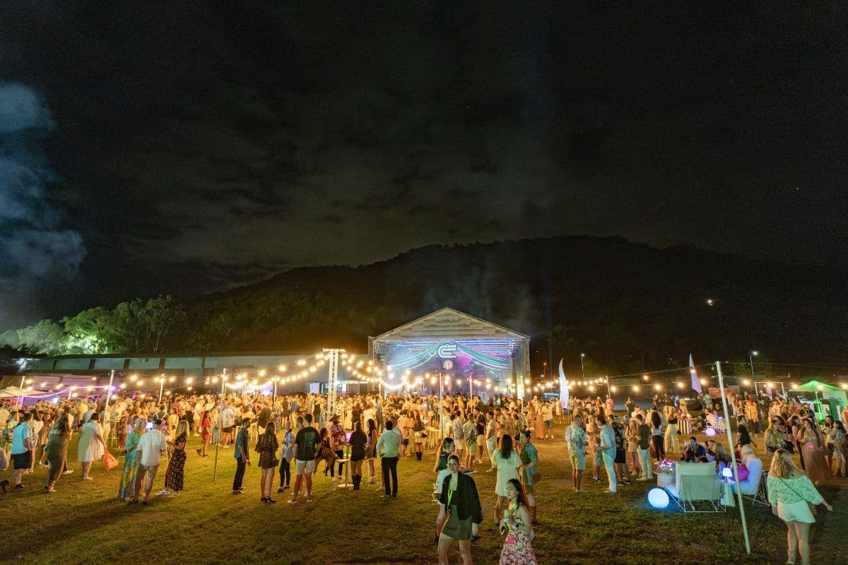 A night crowd under festoon lights outside The Mill's big shed