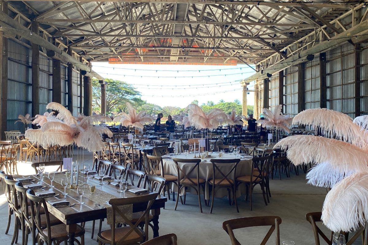 Daytime gala banquet at The 65, long tables and feather centrepieces under the open gable